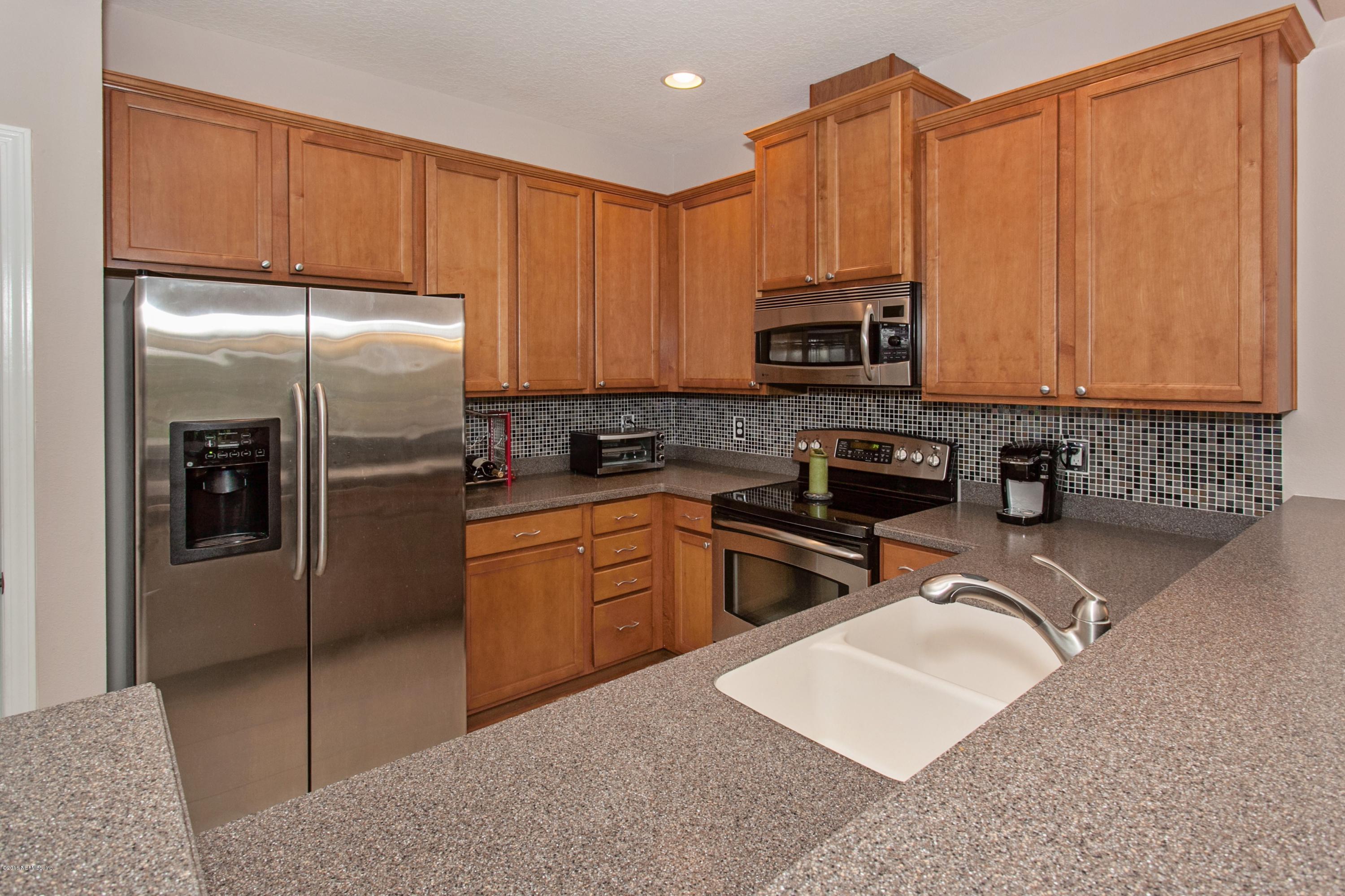 12911 Spring Rain Road Jacksonville, FL 32258 - Photo 4 of 14 a kitchen with stainless steel appliances granite countertop a refrigerator stove and sink