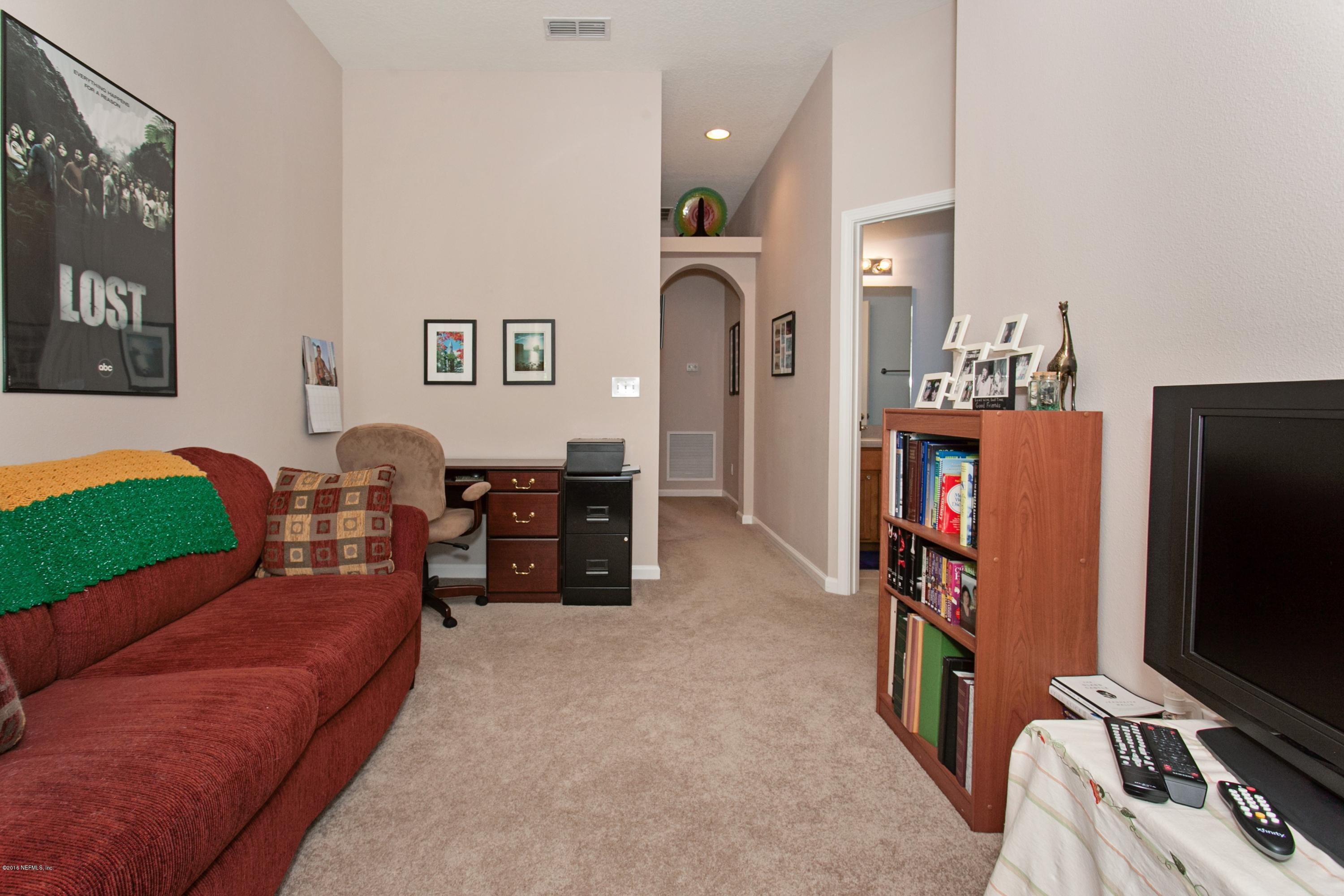 12911 Spring Rain Road Jacksonville, FL 32258 - Photo 8 of 14 a bedroom with furniture and a flat screen tv
