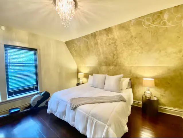 a bedroom with a bed and wooden floor