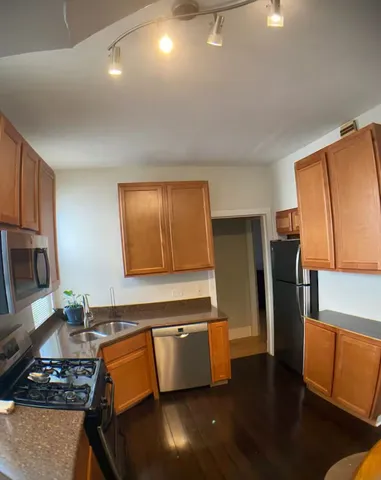 a kitchen with stainless steel appliances granite countertop a refrigerator and a stove top oven