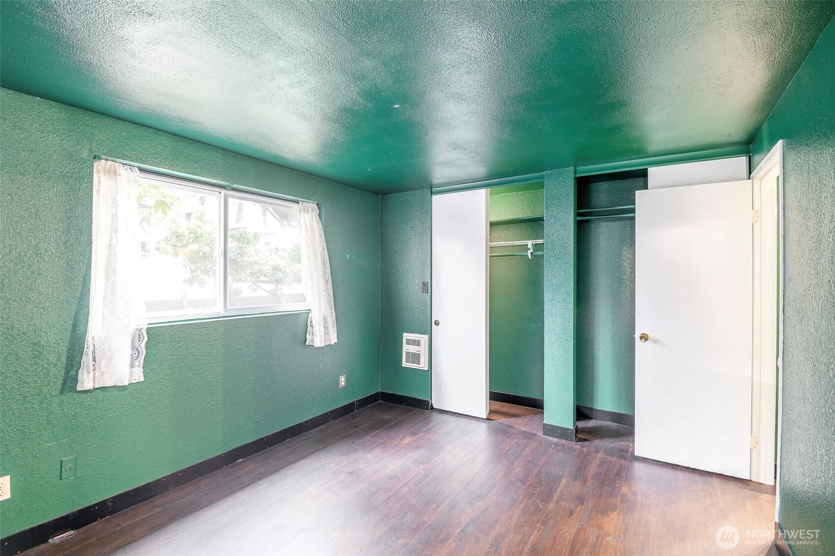 110 Southwest 116th Street, Unit A13 Seattle, WA 98146 - Photo 12 of 16 a view of an empty room with wooden floor and a window