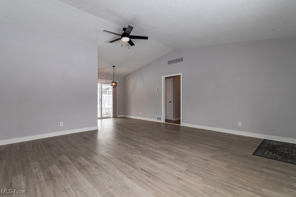 7996 Munson Road Mentor, OH 44060 - Photo 4 of 33 Empty room with lofted ceiling, hardwood / wood-style flooring, and ceiling fan with notable chandelier