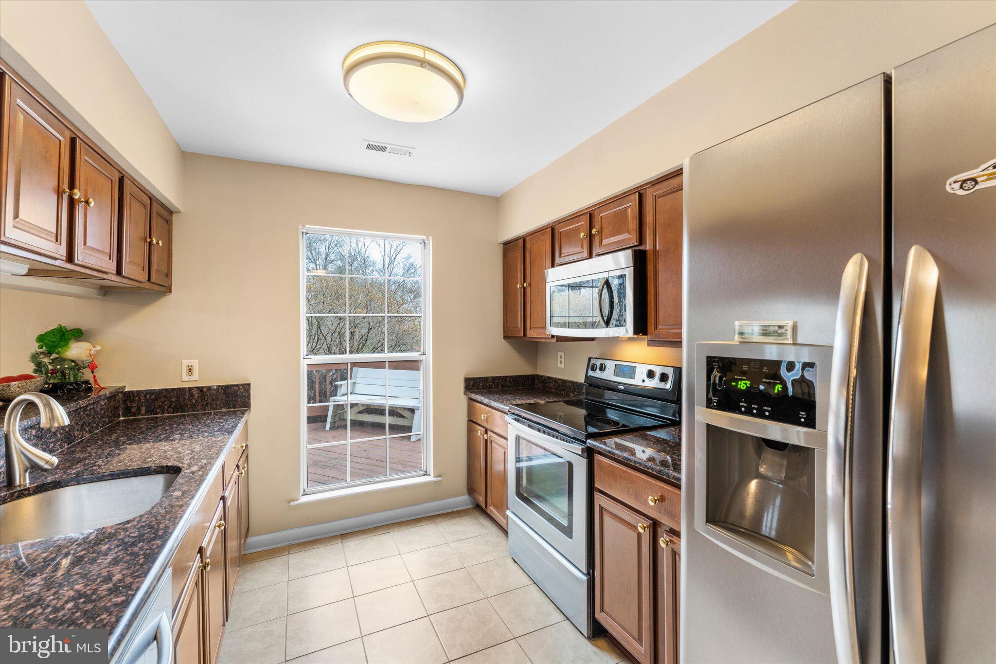 10140 Forest Hill Circle Manassas, VA 20110 - Photo 11 of 42 a kitchen with stainless steel appliances granite countertop a stove a sink and a refrigerator