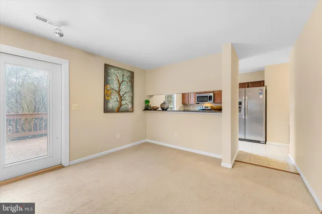 a view of a kitchen with refrigerator and window