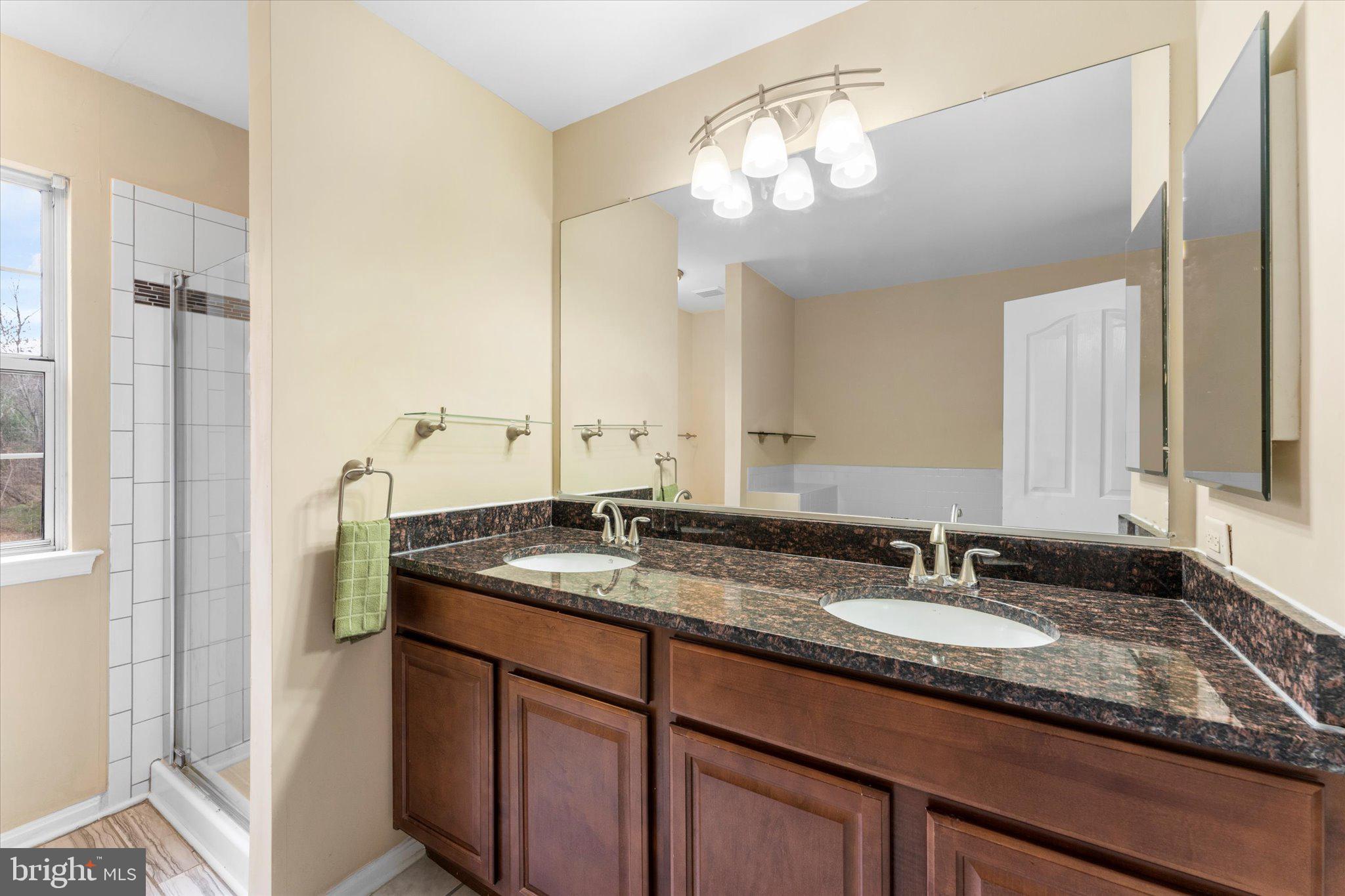 10140 Forest Hill Circle Manassas, VA 20110 - Photo 23 of 42 a bathroom with a granite countertop sink and a mirror