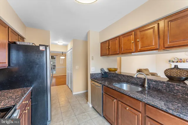 a kitchen with granite countertop a sink and a refrigerator