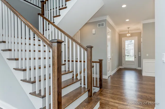 a view of staircase with wooden floor and white walls