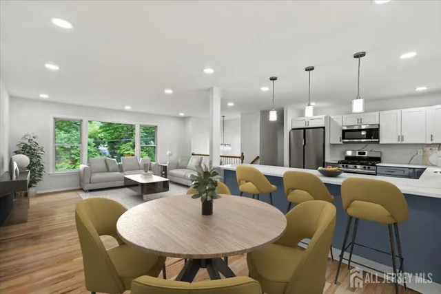 a living room with furniture kitchen view and a large window