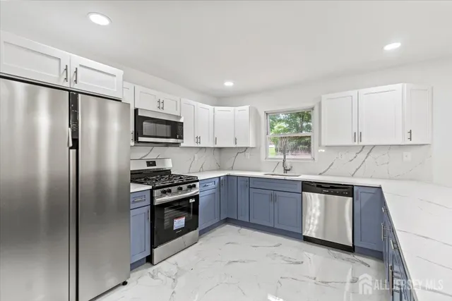 a kitchen with stainless steel appliances granite countertop a stove a sink dishwasher a refrigerator and a microwave