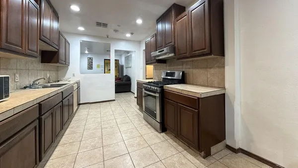 a kitchen with stainless steel appliances granite countertop a sink stove and cabinets