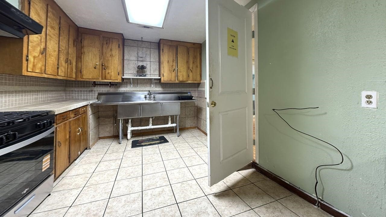 7975 Booker Street Houston, TX 77028 - Photo 22 of 36 a kitchen with a sink cabinets and appliances