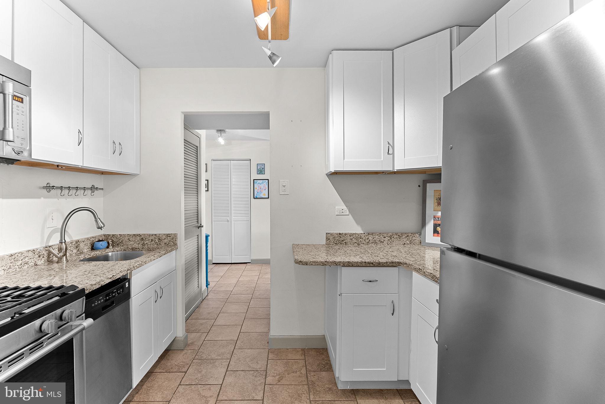5340 Holmes Run Parkway, Unit 400 Alexandria, VA 22304 - Photo 11 of 40 a kitchen with stainless steel appliances granite countertop a sink stove and refrigerator