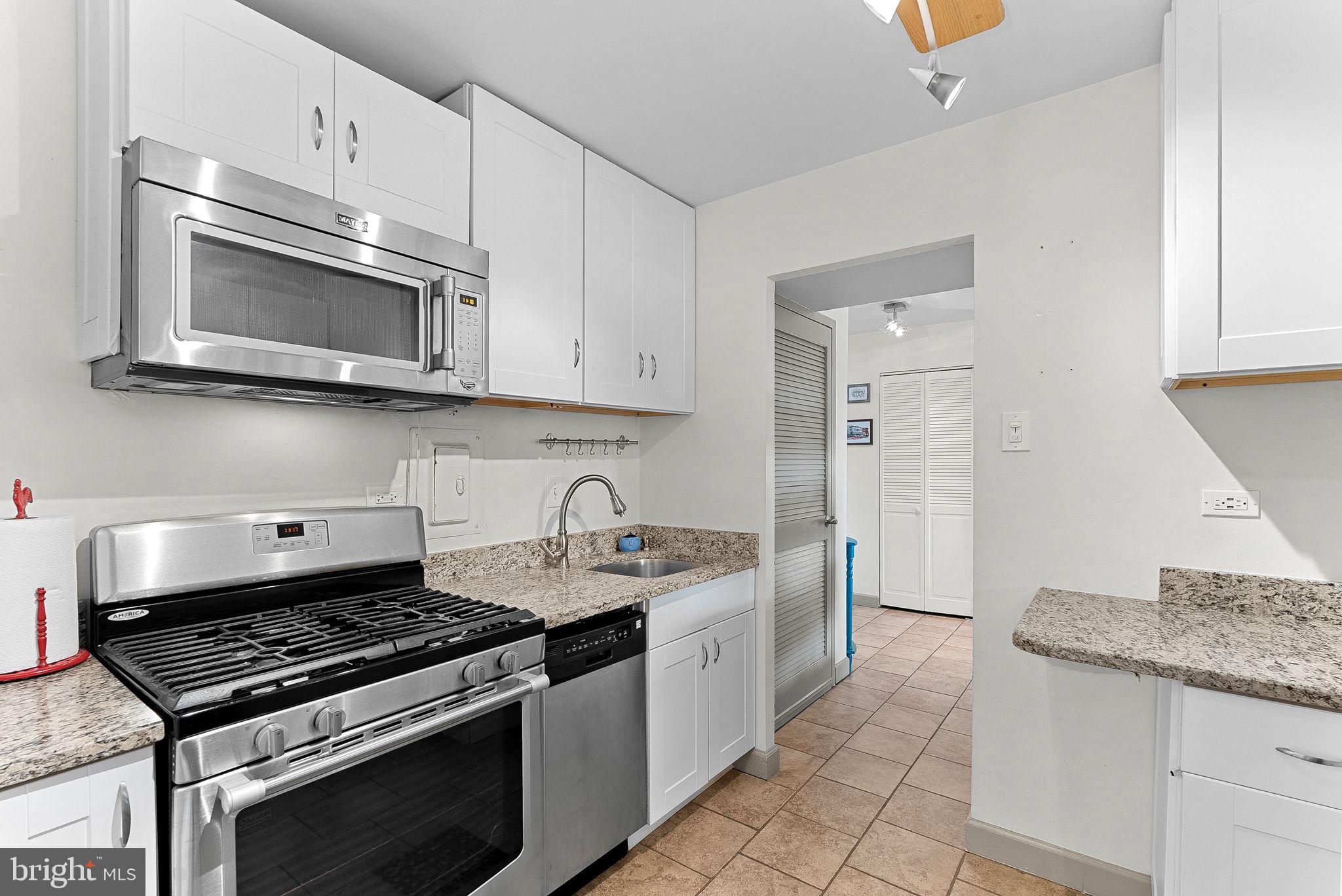 5340 Holmes Run Parkway, Unit 400 Alexandria, VA 22304 - Photo 13 of 40 a kitchen with stainless steel appliances granite countertop a stove and a microwave