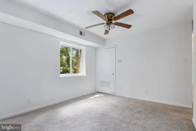 a view of a livingroom with a ceiling fan and window
