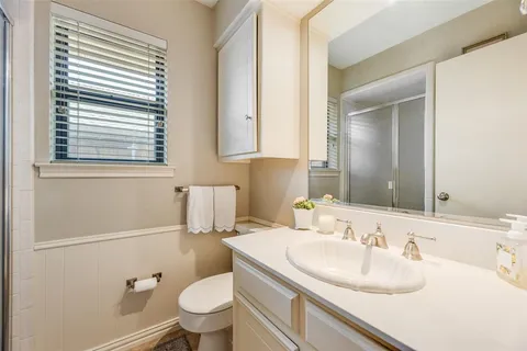 a bathroom with a sink toilet vanity and mirror