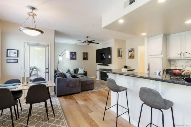 a living room with furniture kitchen view and a flat screen tv