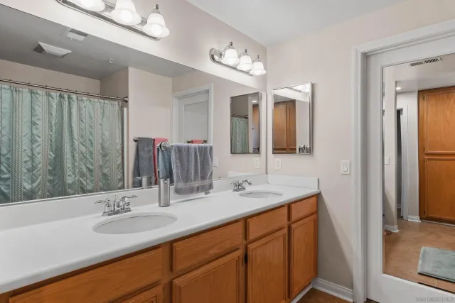 a bathroom with a double vanity sink and a mirror
