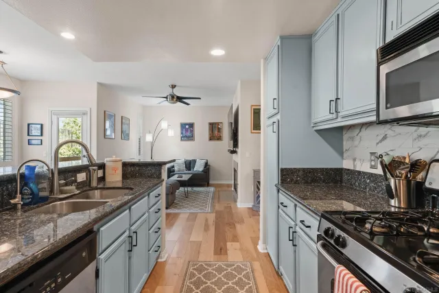 a kitchen with granite countertop a sink stove and cabinets