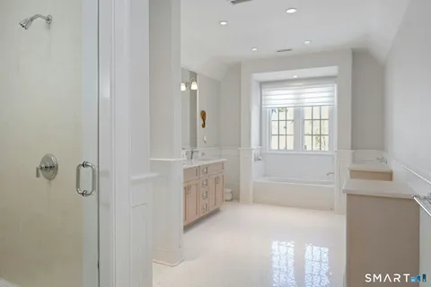 a bathroom with a tub sink vanity and granite