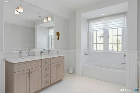 a bathroom with a tub a sink and mirror