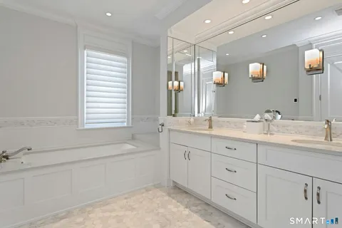 a bathroom with double vanity and a mirror