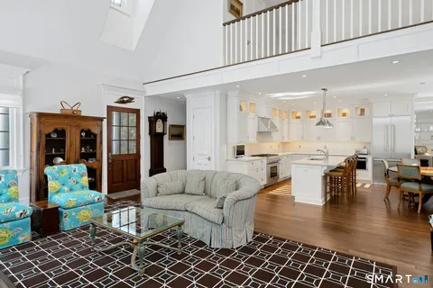 a living room with furniture and a dining table with wooden floor
