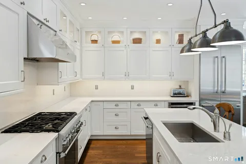 a kitchen with stainless steel appliances granite countertop a sink stove and cabinets