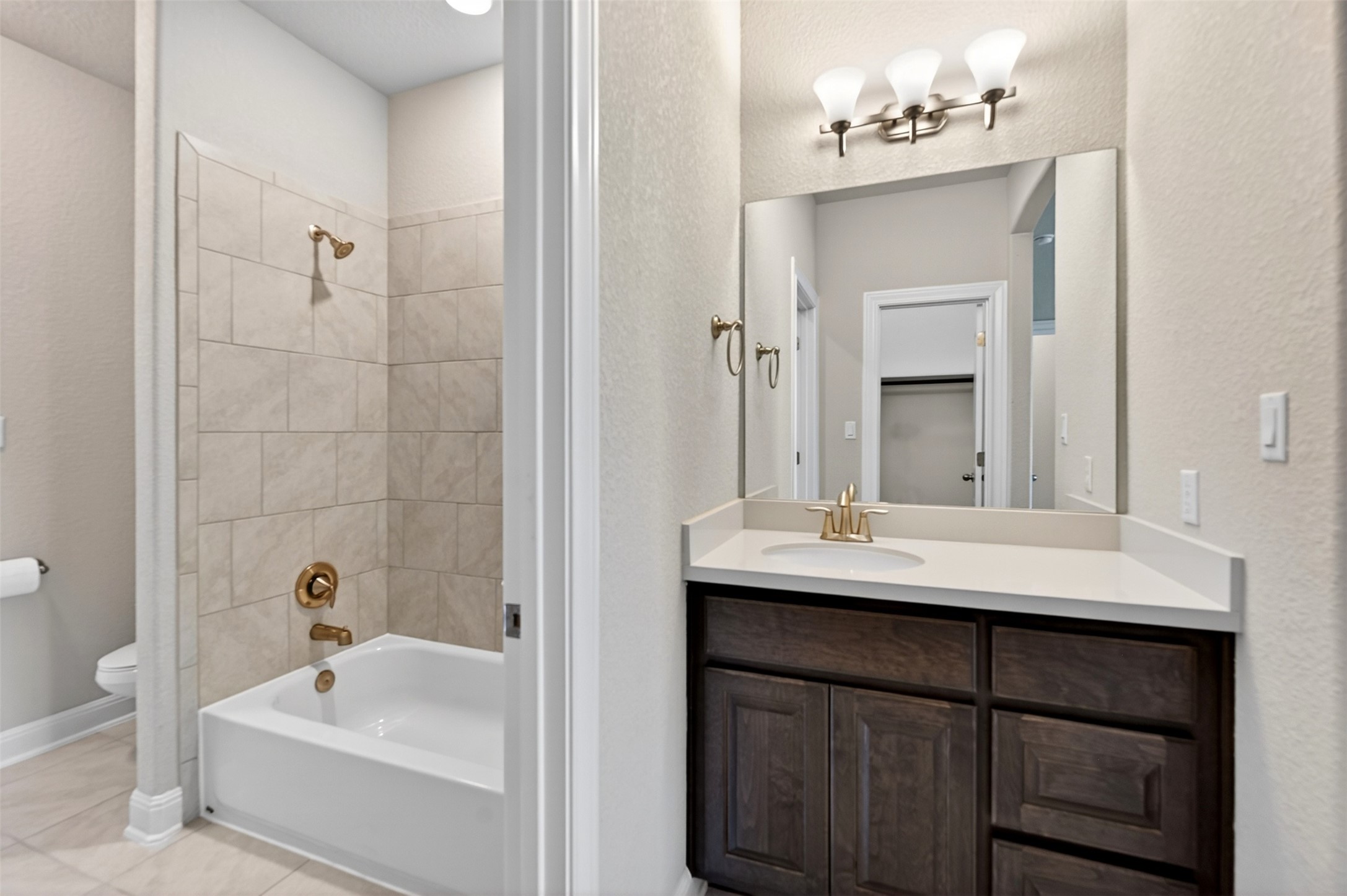 1201 Positano Pass Leander, TX 78641 - Photo 38 of 40 Contemporary vanity with a white countertop, undermount sink, and brushed brass fixtures
