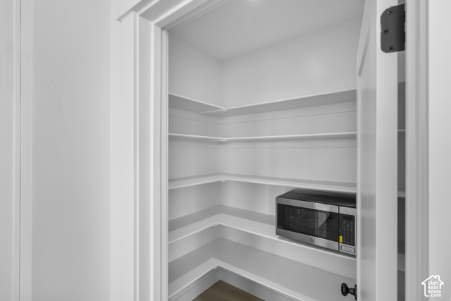 537 South 1150 West Logan, UT 84321 - Photo 14 of 33 Spacious pantry featuring multiple built-in shelves, white walls, and wood-finish flooring