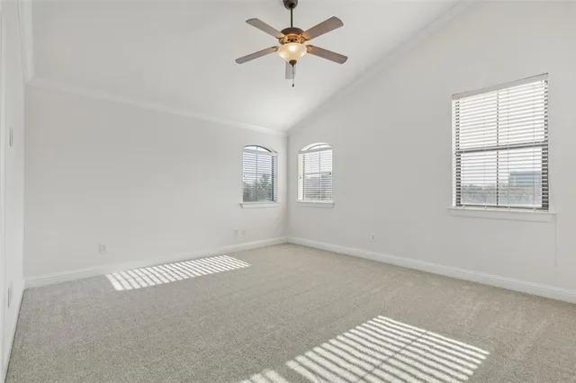 an empty room with windows and ceiling fan