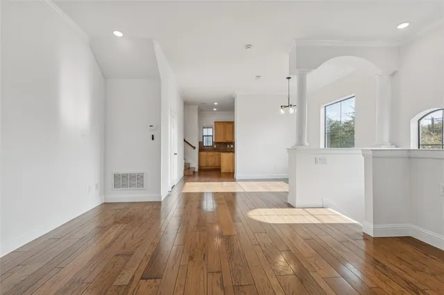 a view of a big room with wooden floor and a kitchen