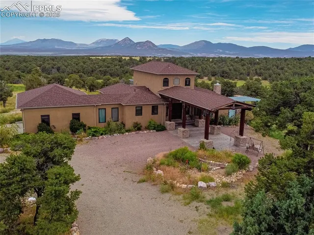 a front view of a house with a yard and mountain