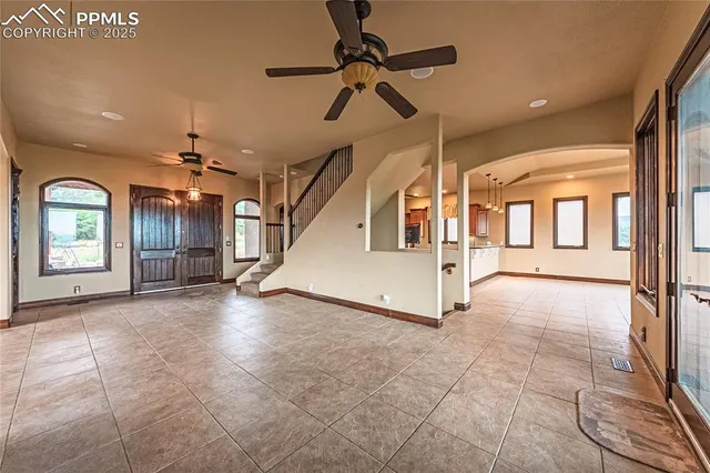 a view of an empty room with window and chandelier