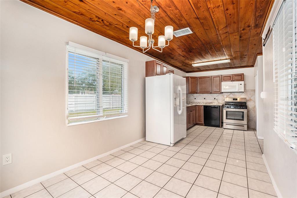 5305 Whiteway Drive Temple Terrace, FL 33617 - Photo 11 of 22 a kitchen with stainless steel appliances kitchen island granite countertop a refrigerator a sink dishwasher and white cabinets with wooden floor
