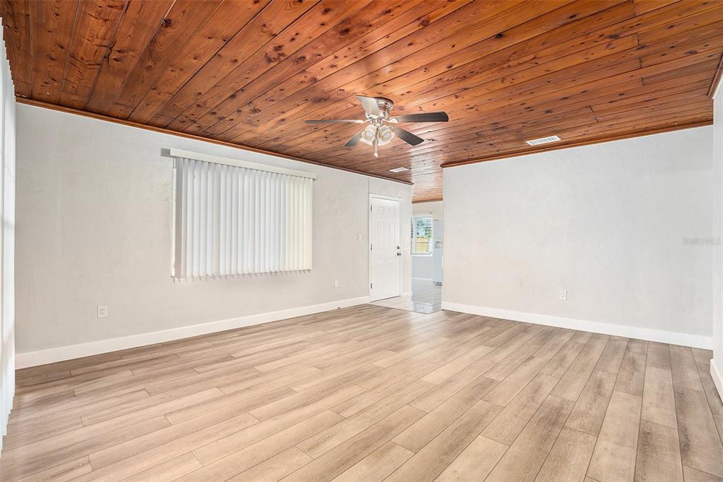 5305 Whiteway Drive Temple Terrace, FL 33617 - Photo 7 of 22 en empty room with wooden floor and windows