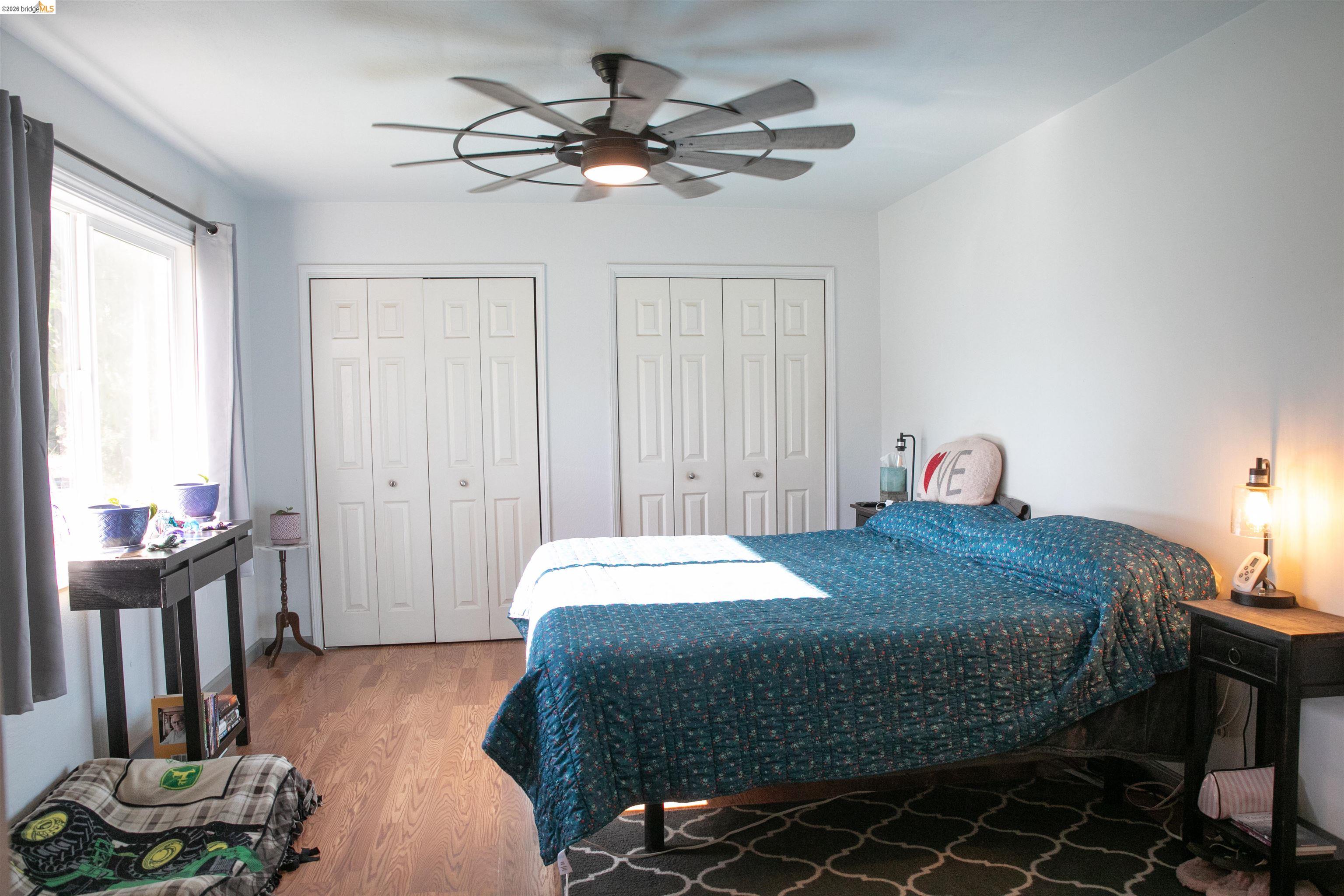 20982 Shaws Flat Road Sonora, CA 95370 - Photo 21 of 26 Bright interior space featuring wood-finish flooring, a contemporary ceiling fan, and two sets of bi-fold closet doors