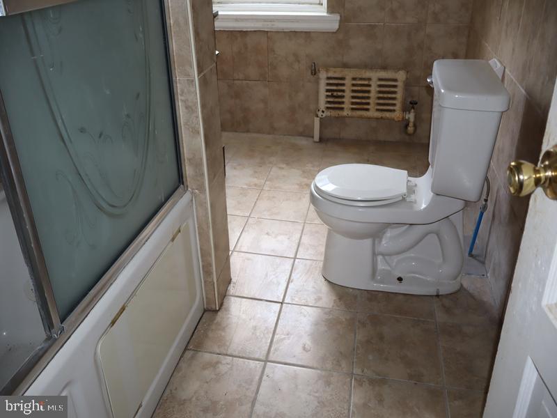 6386 Sherwood Road Philadelphia, PA 19151 - Photo 12 of 18 a bathroom with a toilet and a shower