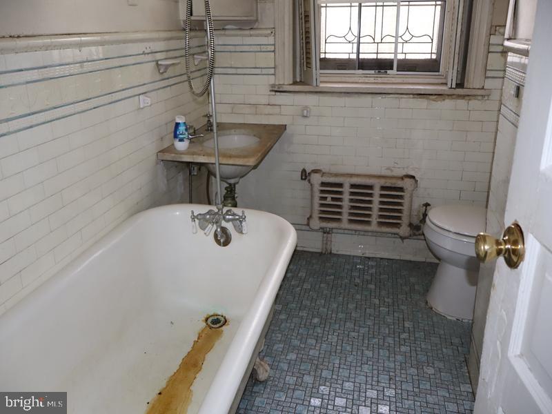 6386 Sherwood Road Philadelphia, PA 19151 - Photo 16 of 18 a bathroom with a sink a toilet and window