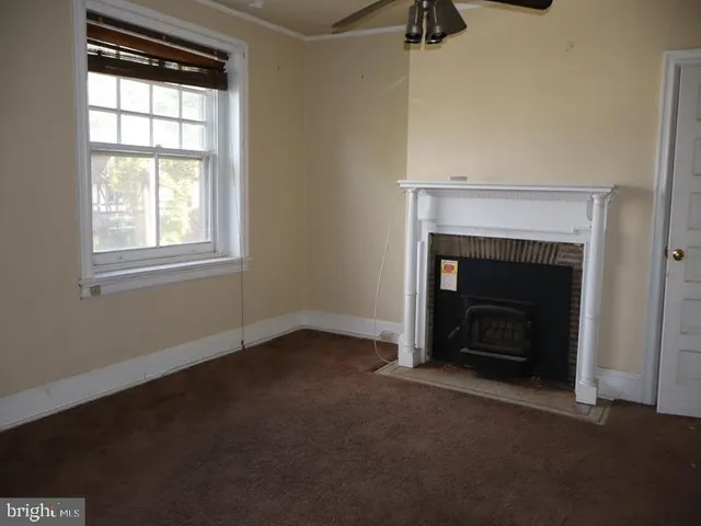 an empty room with windows and fireplace