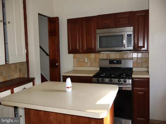 a kitchen with a sink a microwave and cabinets