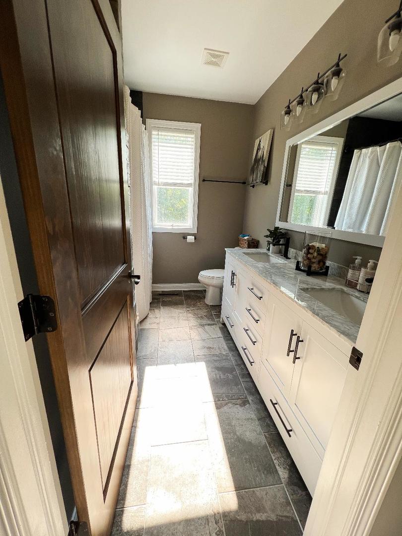 3503 Deep Cut Road Woodstock, IL 60098 - Photo 17 of 34 a bathroom with a double vanity sink a mirror and a bathtub