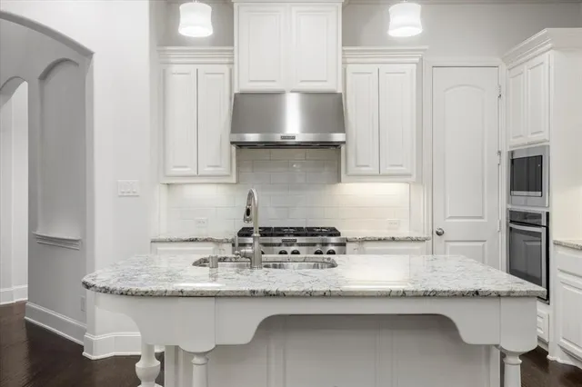 a kitchen with granite countertop a sink and cabinets