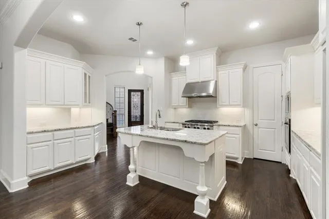 a kitchen with a stove a sink and a refrigerator