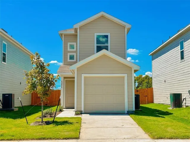 a front view of a house with a yard and garage