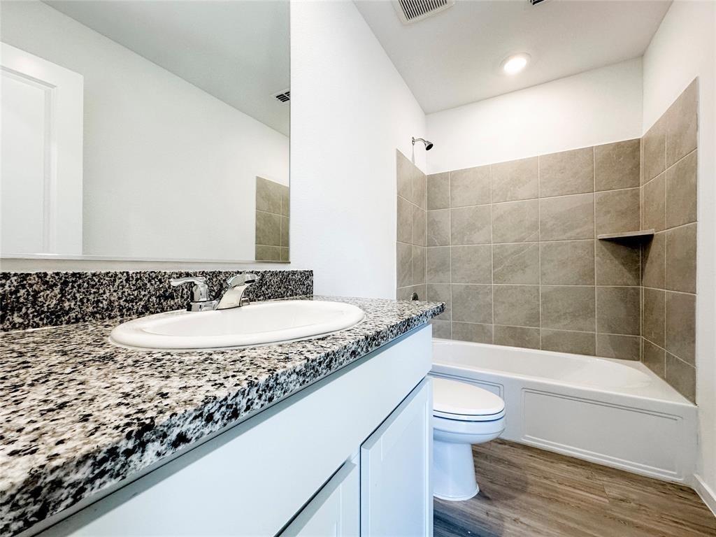 6206 Sanderling Street Princeton, TX 75407 - Photo 10 of 15 a bathroom with a granite countertop sink a toilet and bathtub
