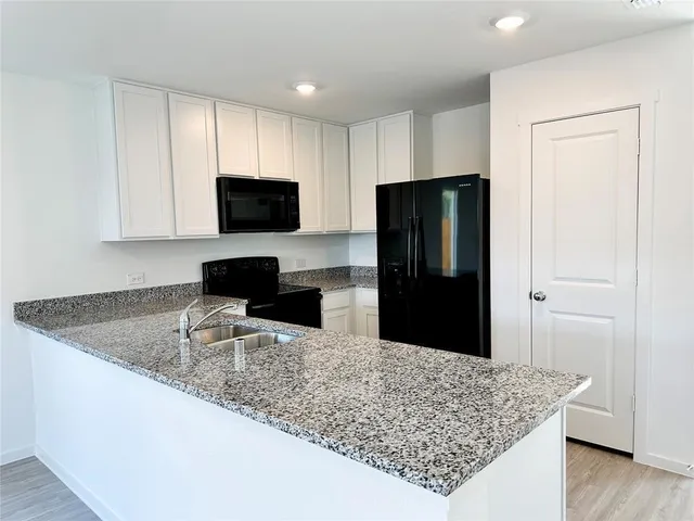 a kitchen with stainless steel appliances granite countertop a refrigerator and a granite counter tops