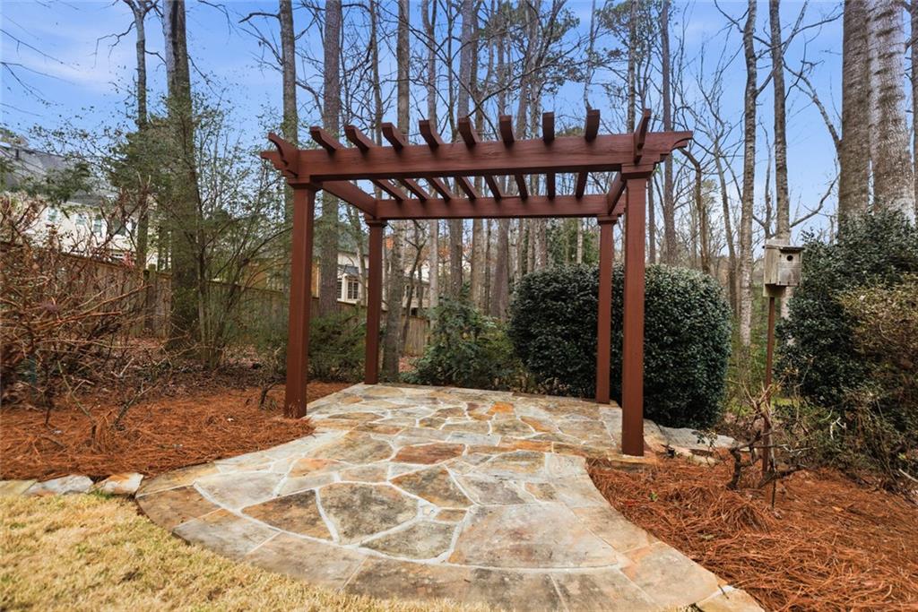 3463 Buck Hill Road Marietta, GA 30067 - Photo 77 of 82 a backyard of a house with large trees and wooden fence