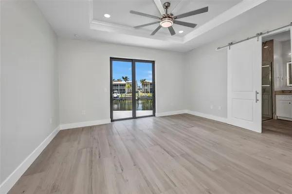an empty room with wooden floor closet and windows