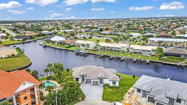 an aerial view of residential houses with outdoor space and lake view