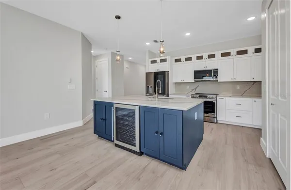 a kitchen with stainless steel appliances kitchen island granite countertop a stove a sink and a refrigerator